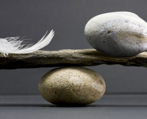 Balanza equilibrada con piedra y pluma